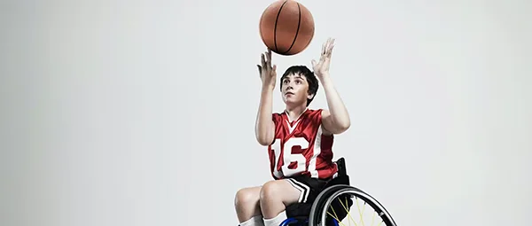 youth in wheelchair playing basketball