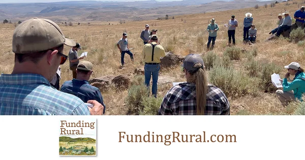 A group of people standing in a rural field.