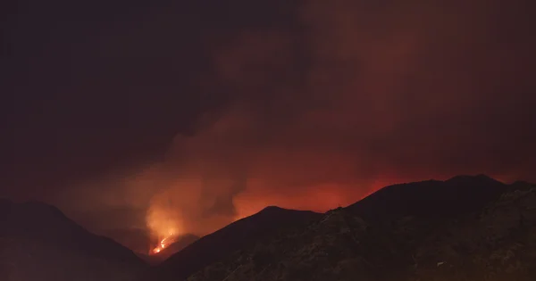 wildfire over the hills at night in California