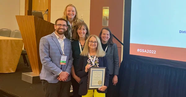 Group photo of five people at a conference
