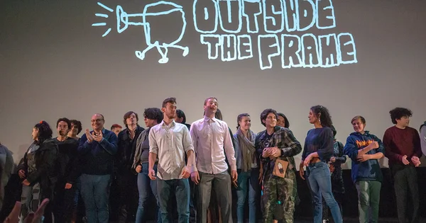 Group of people standing on stage under a "Outside the Frame" logo
