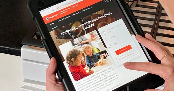 Tablet screen displaying a website for a course about nourishing children, with two young children visible in an image on the page.