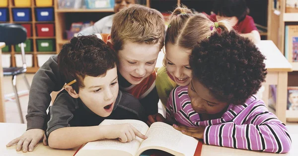 Group of young children collaboratively reading a book, symbolizing early literacy, curiosity, and learning in a supportive environment.