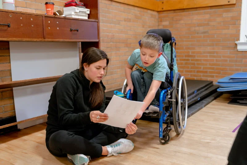 An adult and a kid looking at a piece of paper