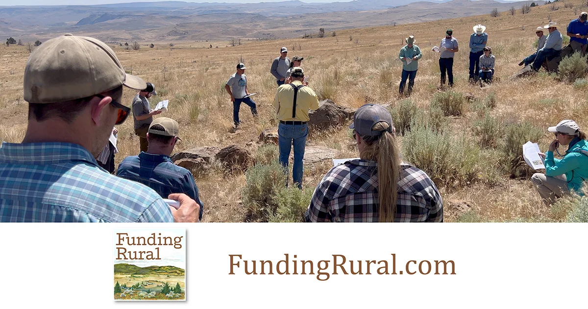 A group of people standing in a rural field.
