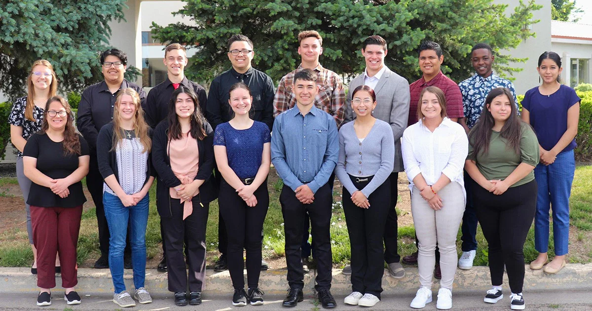  Group portrait of a diverse group of young people standing together outdoors.