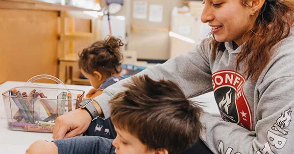 An early childhood education student works with children in a classroom.