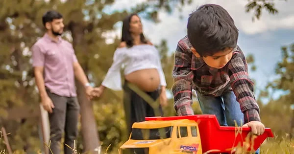 A young boy playing with his parents nearby, illustrating the development of a family.