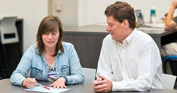 Academic advising or tutoring session taking place at a table in the Mathematics and Statistics Learning Center, illustrating focused support for student work.