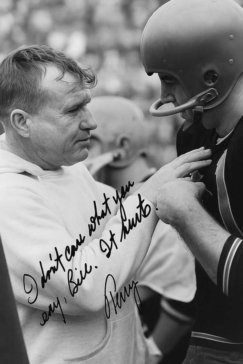Black and white signed photo of Athletic Trainer Bill "Ropes" Robertson speaking to player Terry Baker with the handwritten quote: "I don't care what you say, Bill. It hurts. Terry.