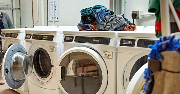 A clean, organized campus laundry facility, illustrating an essential service for students or residents and symbolizing basic needs support.