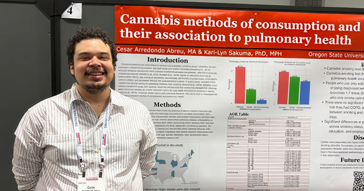 Cesar Arredondo Abreu smiles while standing next to his research poster titled, "Cannabis methods of consumption and their association to pulmonary health."
