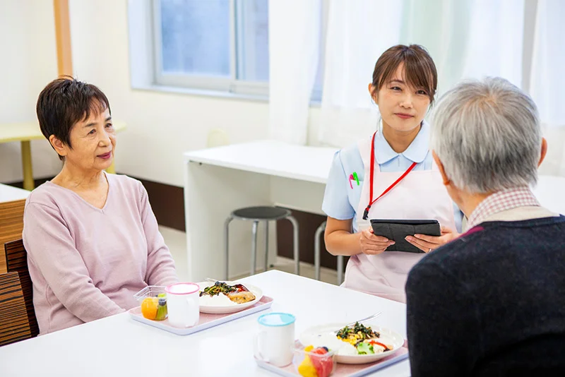 A clinical dietitian provides geriatric nutrition counseling in an assisted living or long-term care facility, emphasizing meal planning for older adults.
