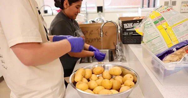 Volunteers in a campus food pantry preparing produce, illustrating student engagement in food security and community service.