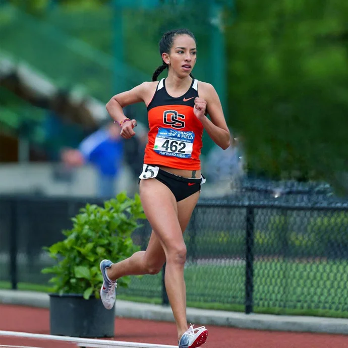 An Oregon State University track and field student-athlete in mid-stride during a race, illustrating the dedication, physical excellence, and competitive spirit of the university's athletic programs.