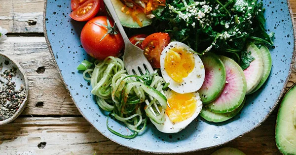 A colorful, nutrient-dense salad bowl, illustrating the principles of preventative health, balanced nutrition, and wellness resources for students.