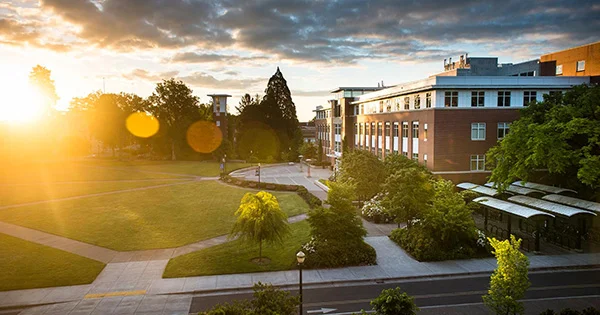 A scenic view of the Oregon State University campus at golden hour, representing the welcoming environment and architectural landmarks associated with the Scholarship Office.