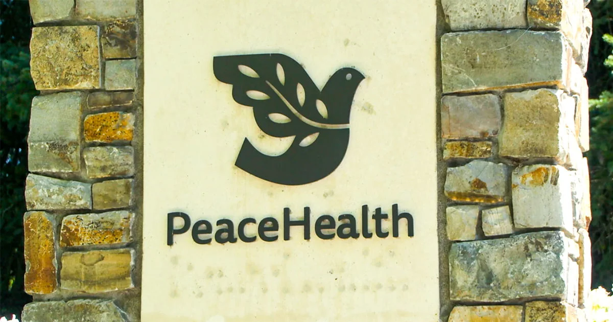 PeaceHealth logo showing a stylized black dove with leaf-patterned wings above the text PeaceHealth, set against a stone pillar.