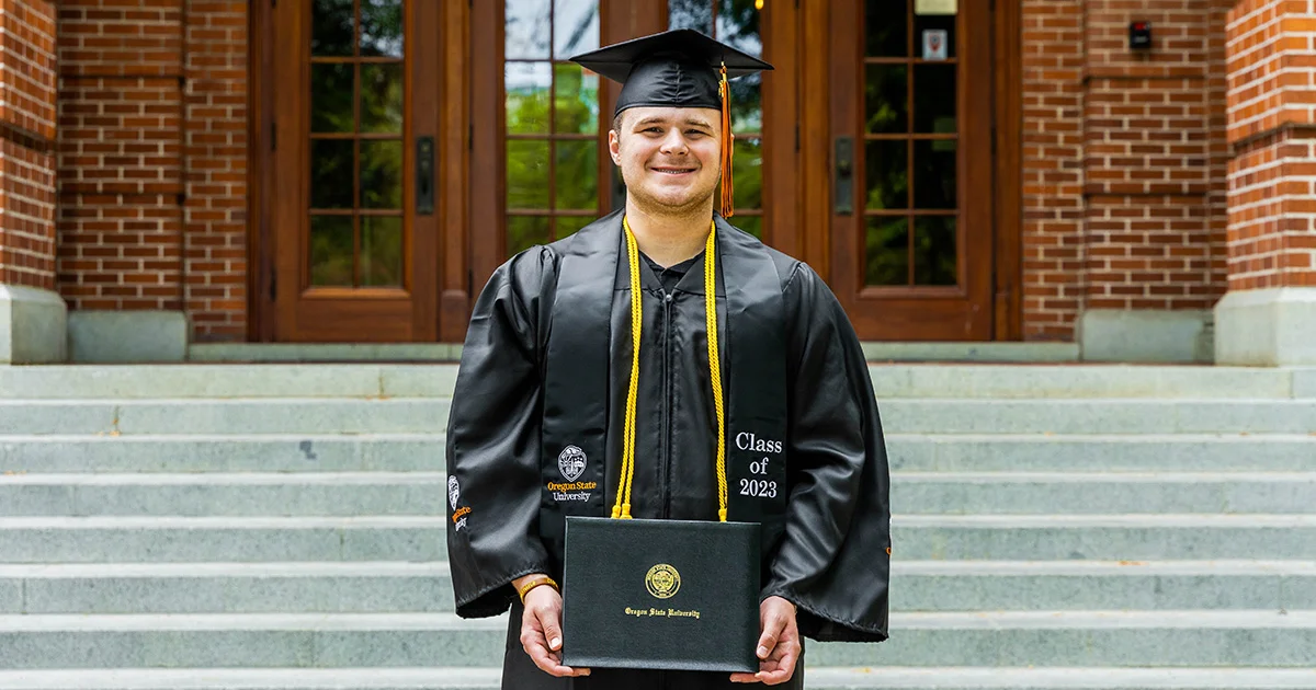 Kaleb Messner holding his diploma
