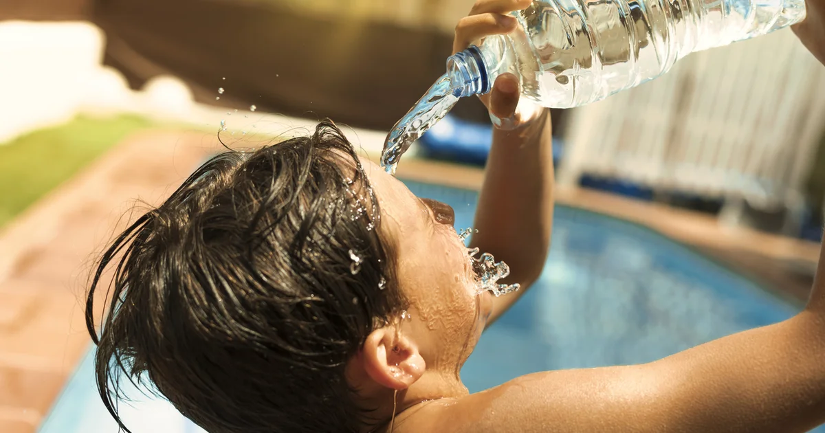 boy pouring water on face on a hot day