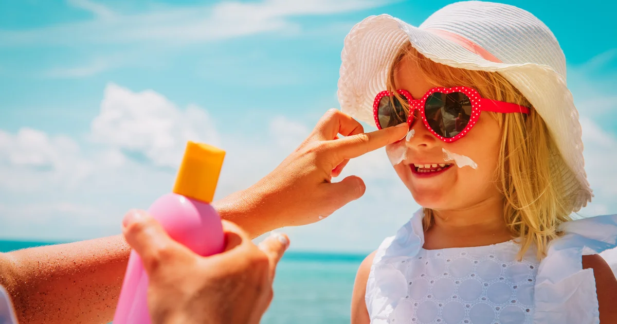 adult applying sunscreen to child's face