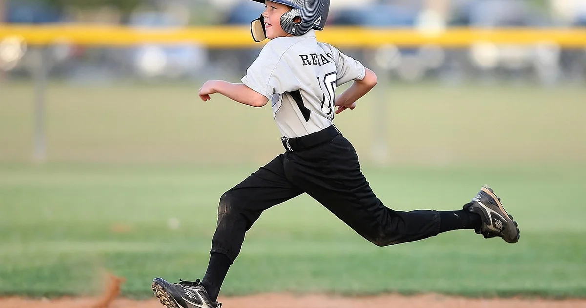 child playing baseball running to a base
