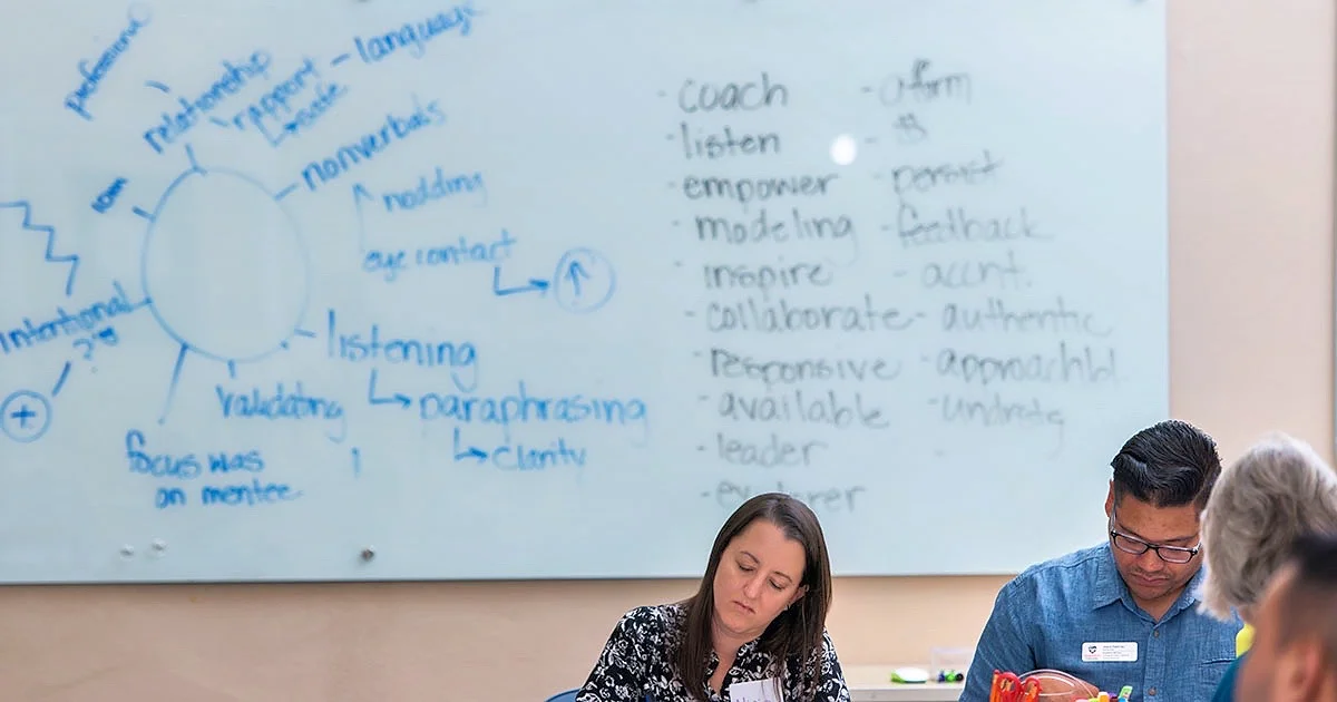 A group of students taking notes at a workshop on professional skills and leadership.