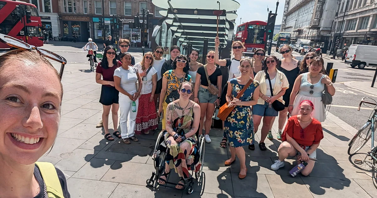 A group of students smiling during a study abroad trip in a busy city, illustrating hands-on, international learning.