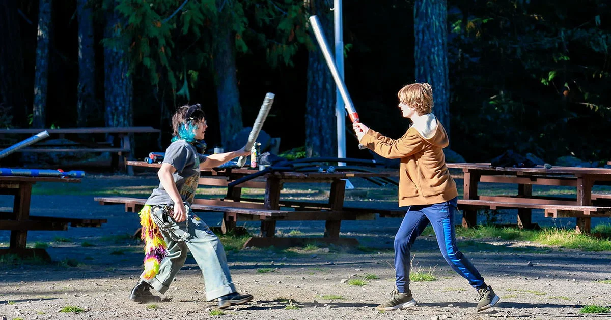 Youth participating in a playful, fantasy-themed activity or camp roleplaying event, symbolizing creativity, teamwork, and outdoor adventure.